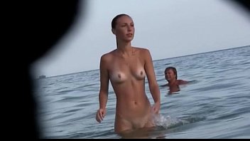 Watch a naked chick at the beach tan her hot body